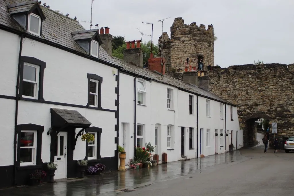 A row of white houses in Conwy with the castle turret in the background