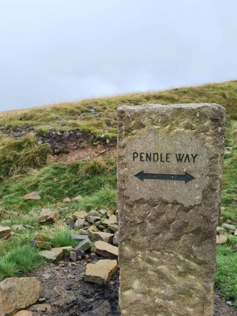 A stone waymarker with Pendle Way written on in black
