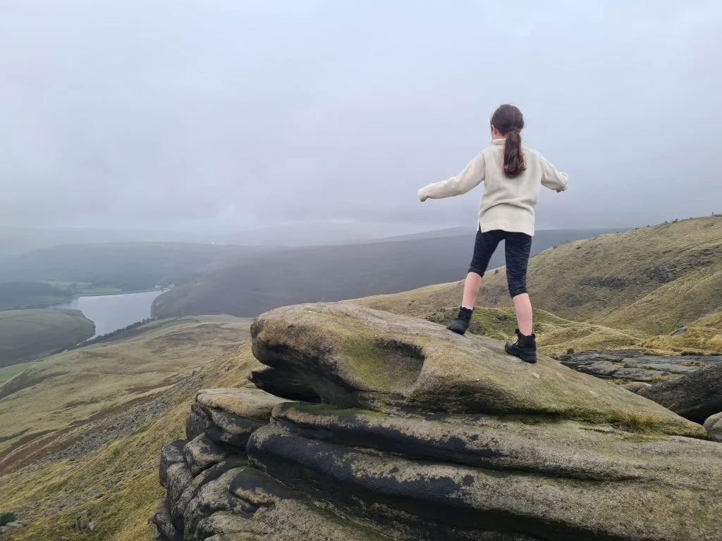 Climbing on rocks with a view down to Kinder Reservoir