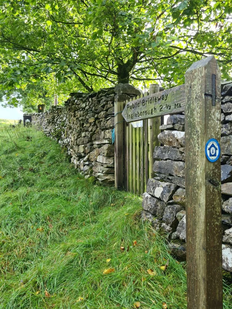 Wooden signpost saying Ingleborough 2 1/2 miles - Ingleborough from Ingleton
