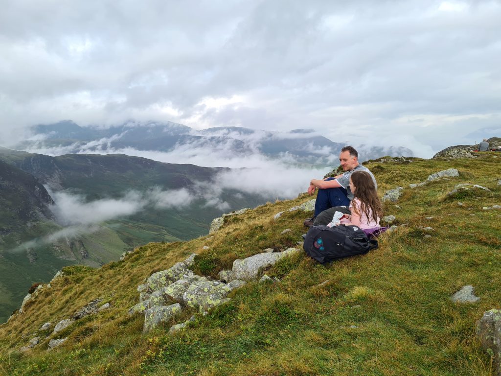 A man and his daughter sitting on High Spy, in the Lake District