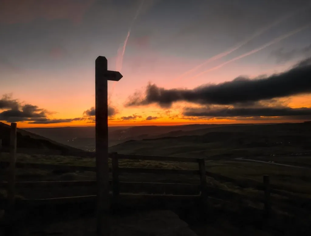 Sunrise at Mam Tor - A signpost silhouetted against a colourful sunrise - The Wandering Wildflower