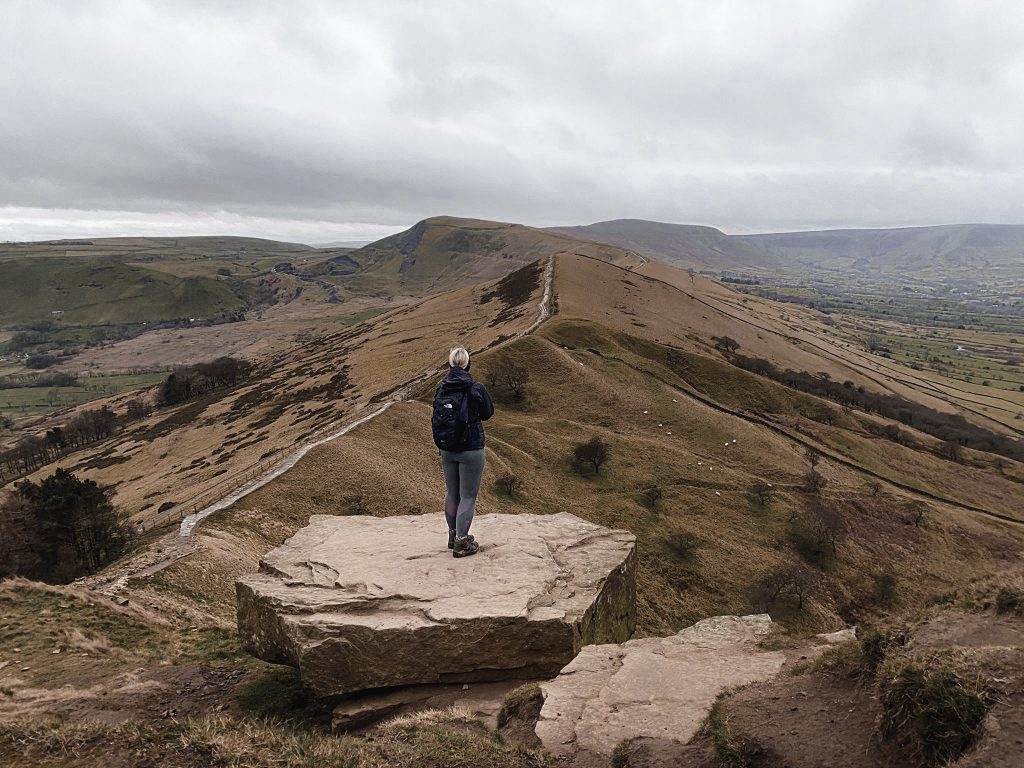 A woman looking along The Great Ridge towards Mam Tor (from Back Tor)