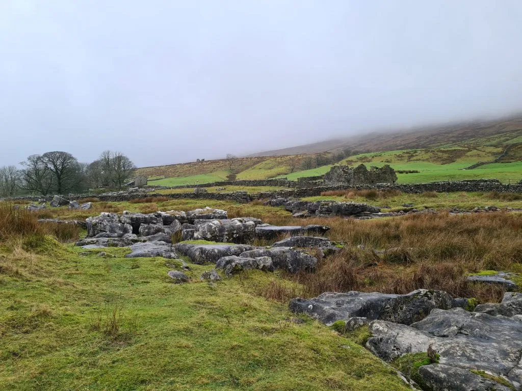 Rock formations with a misty Whernside in the background