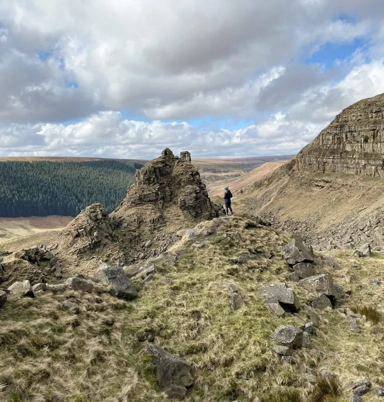 A woman stood looking at Alport Castles