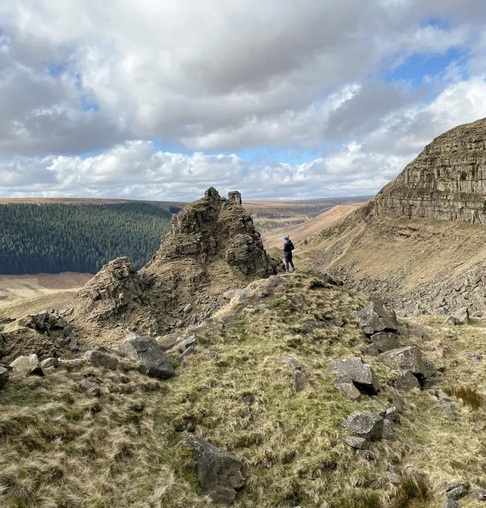 A woman stood looking at Alport Castles