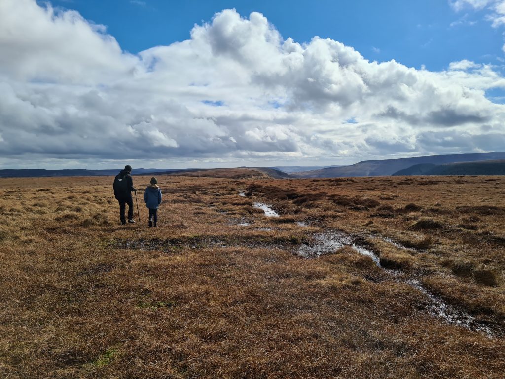 A man and his daughter walking on the open moors