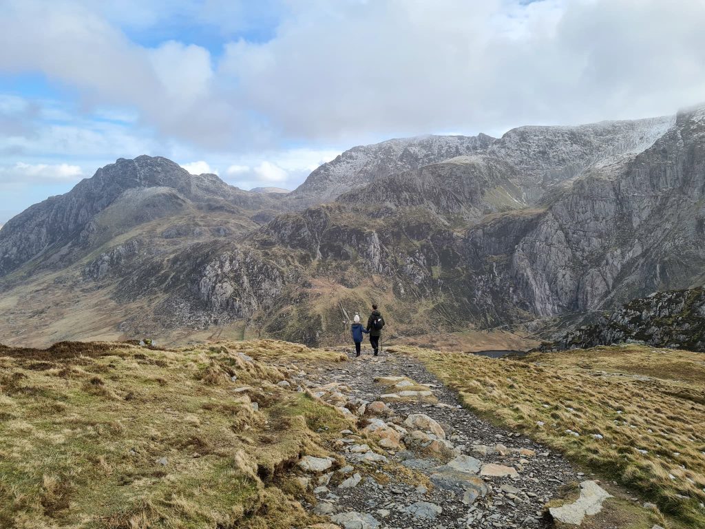 A father and daughter walking through the Ogwen Valley with Tryfan in the background