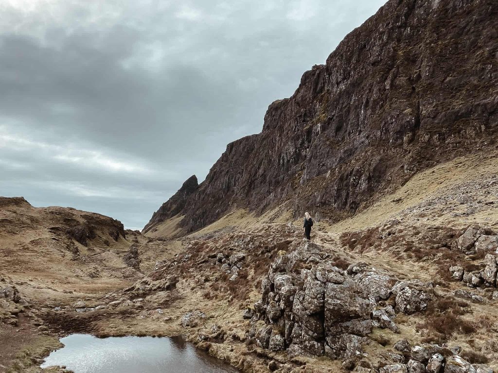 Walking through The Quiraing past a small mountain pool