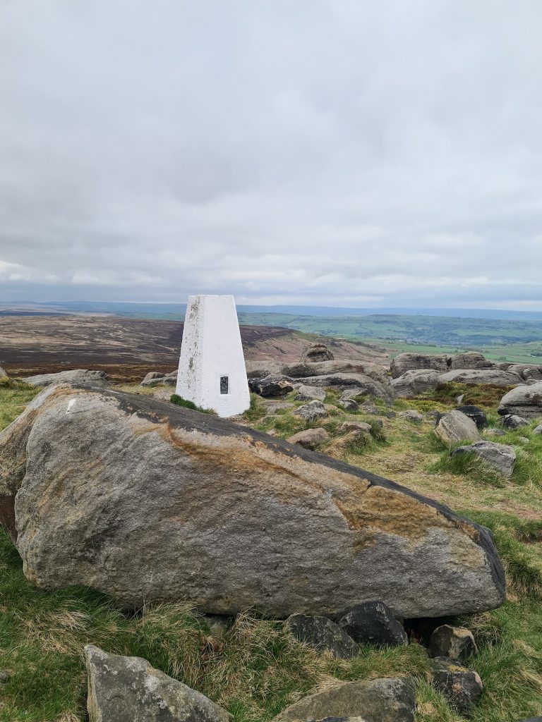 West Nab trig point surrounded by rocky outcrops