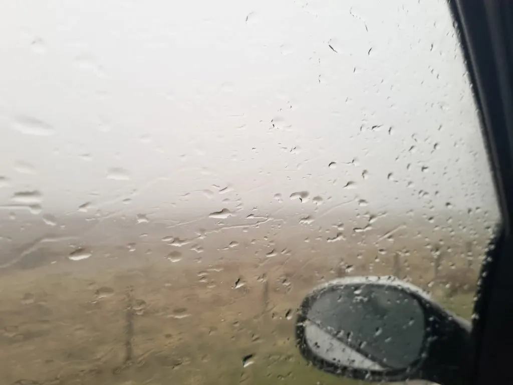 View from the passenger side of a car of rain and mist