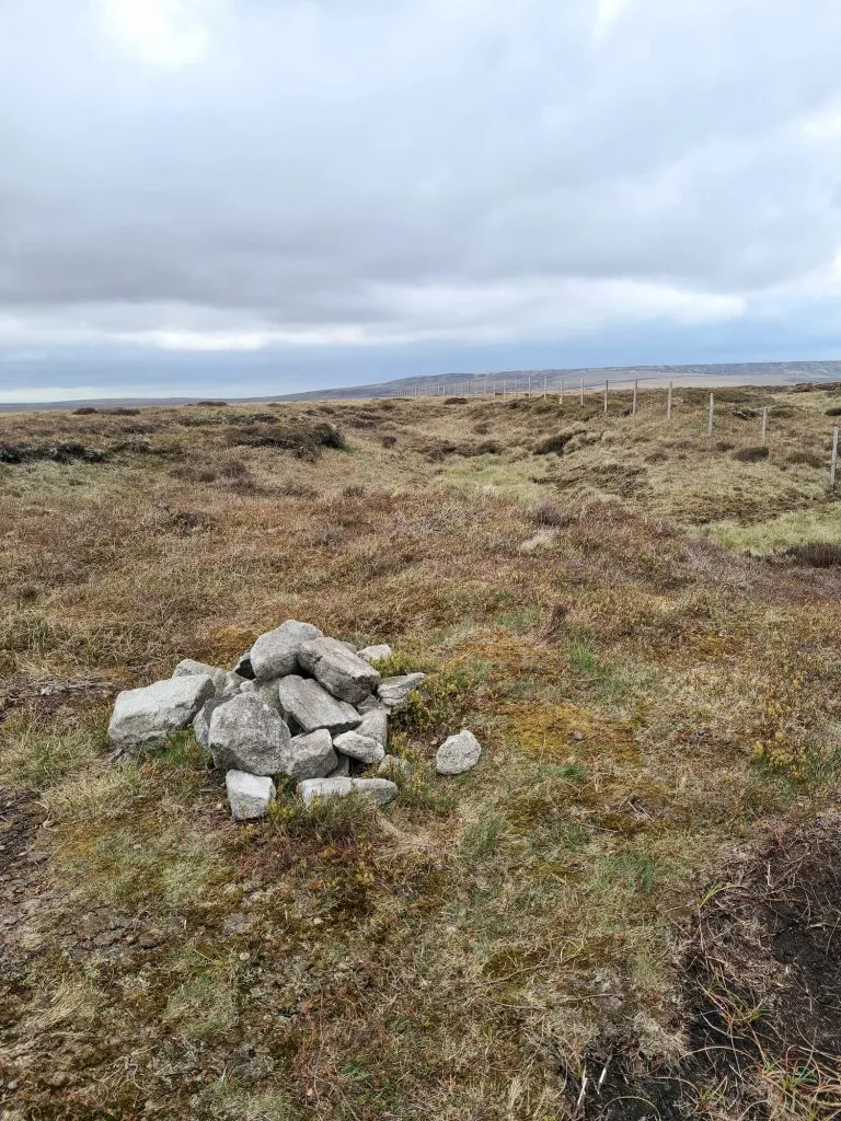 A stone cairn marking the summit of Black Chew Head, the County Top of Greater Manchester