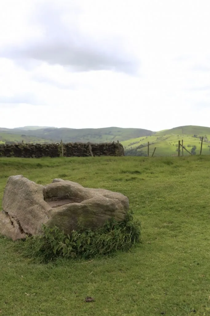The Dipping Stone, an ancient stone with two rectangular holes in the top, with views to Sponds Hill