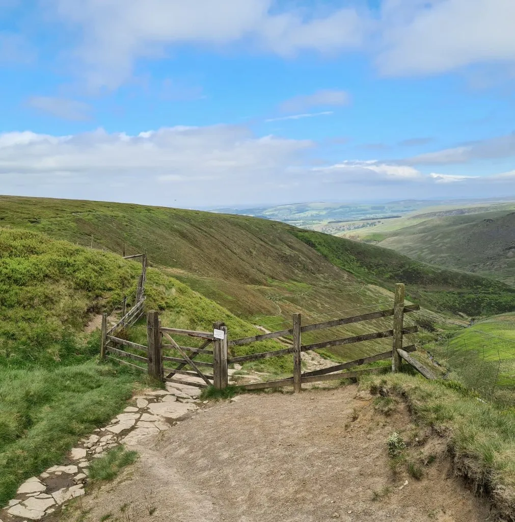 A wooden gate leading to a trackway through a moorland valley - Doctors Gate path near Higher Shelf Stones