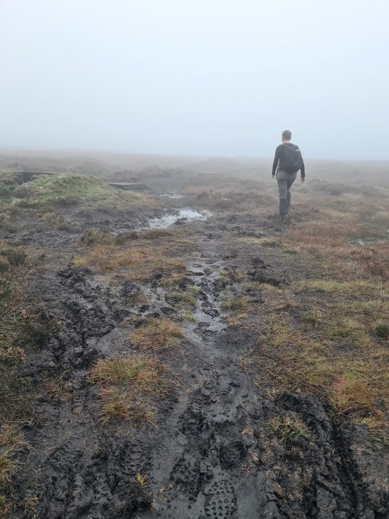 A man walking on very boggy moors