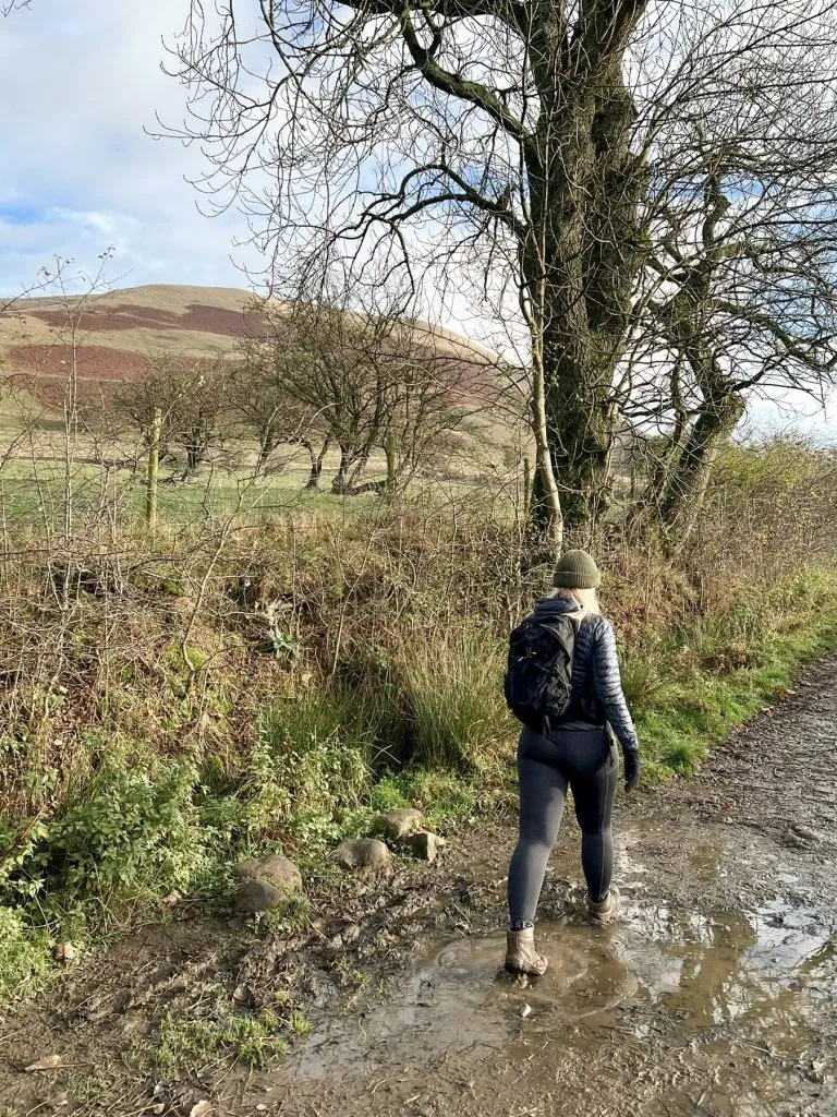 A woman walking in a muddy puddle