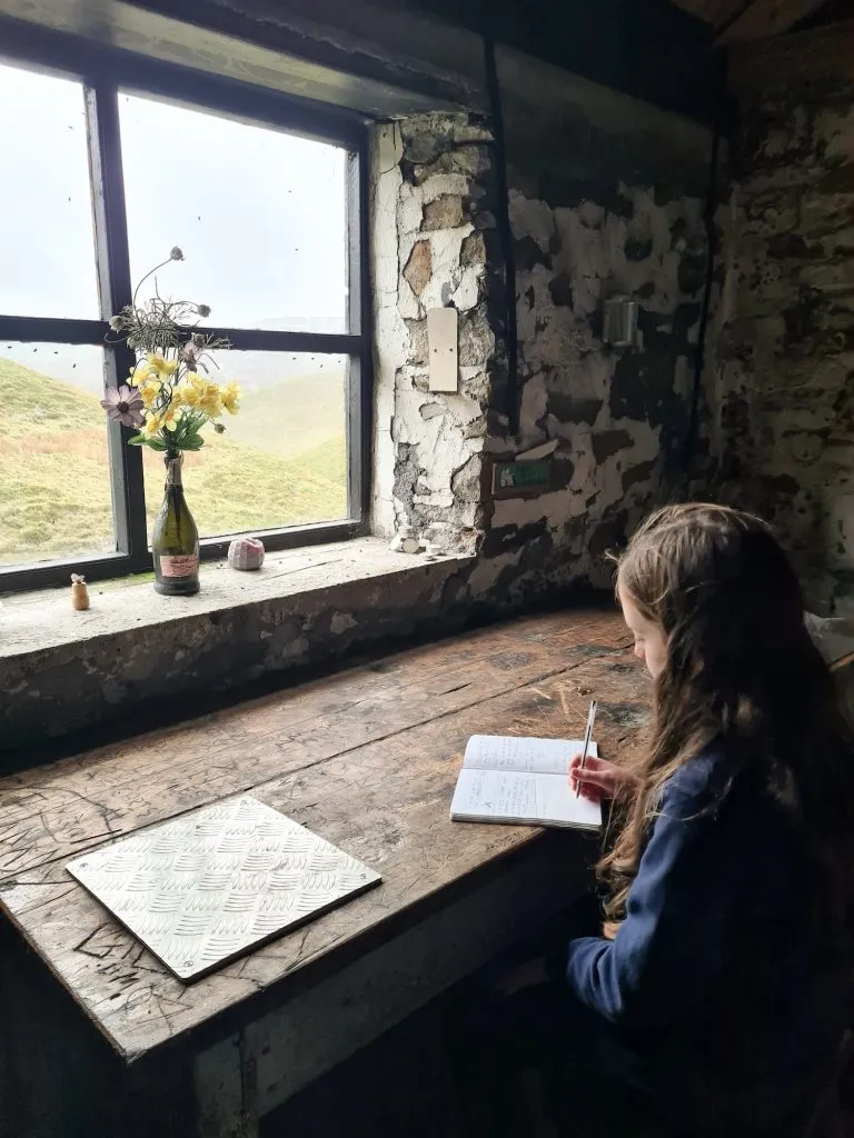 A small girl sitting at a desk with a notebook