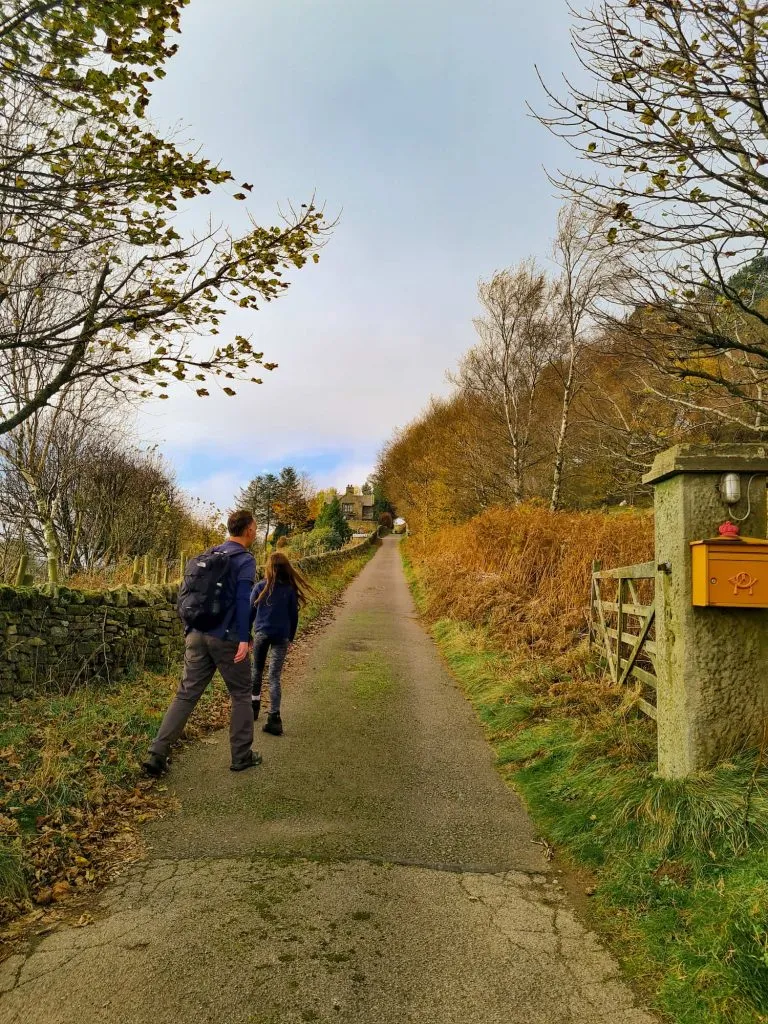 A man and his daughter heading up a footpath up a driveway