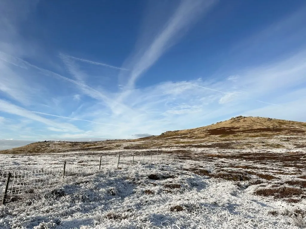 West Nab, a rocky peak, in the winter sunshine with blue skies