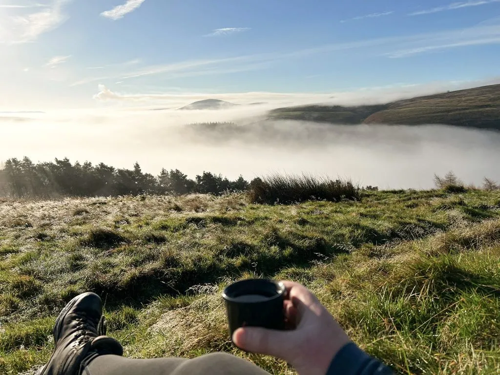 A cup of tea in the foreground with a cloud inversion