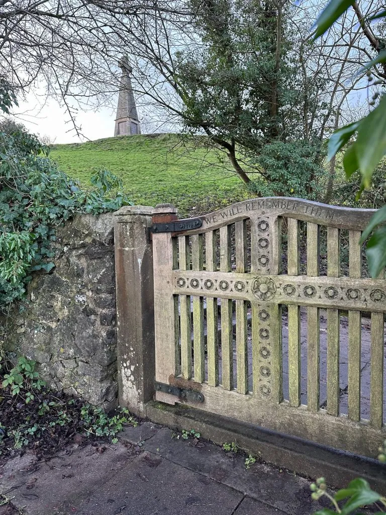 A wooden gate with Pic Tor war memorial in the background
