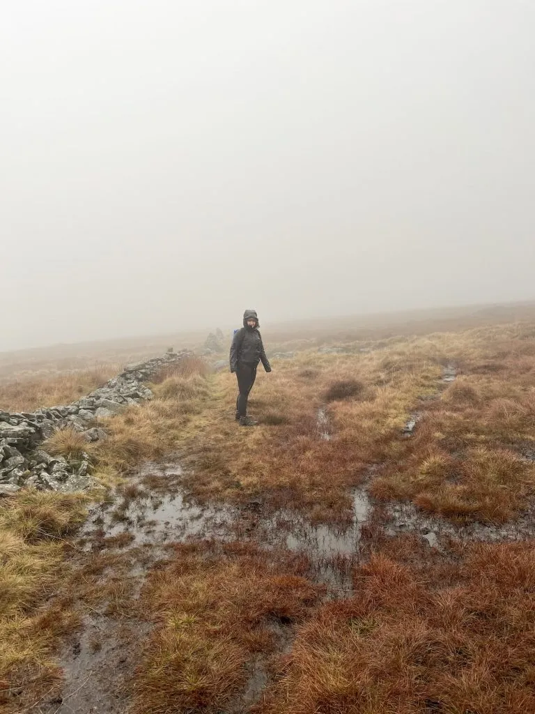 A woman stood on a wet boggy moorland