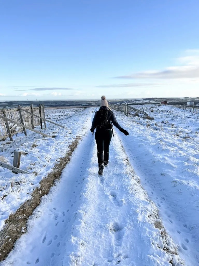 A woman walking along the Snow Road - The Wandering Wildflower