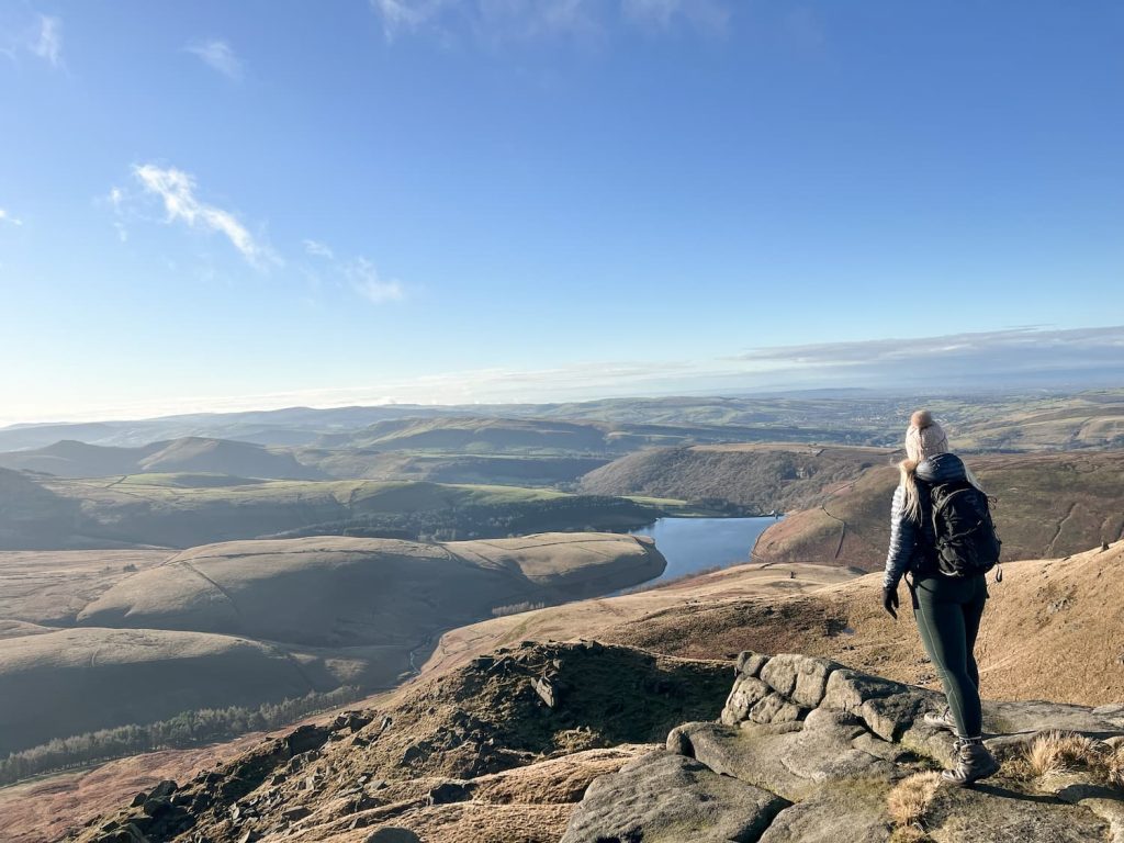 A woman looking down over Kinder Reservoir from Kinder Scout