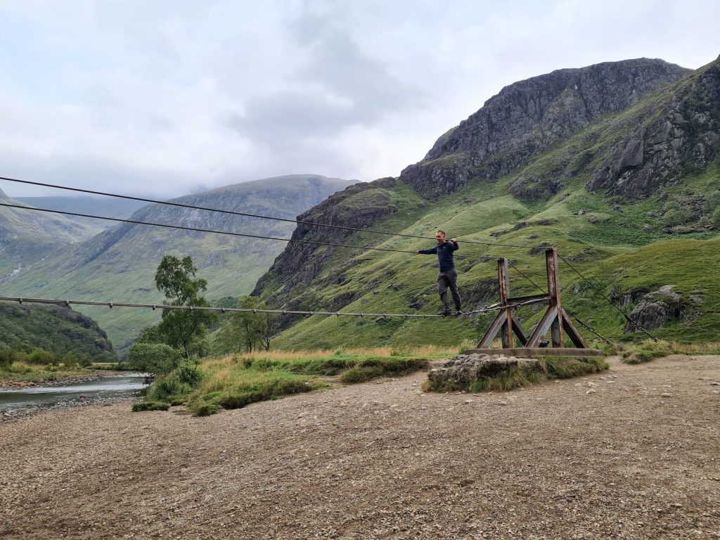 A man on the wire bridge crossing the River Nevis