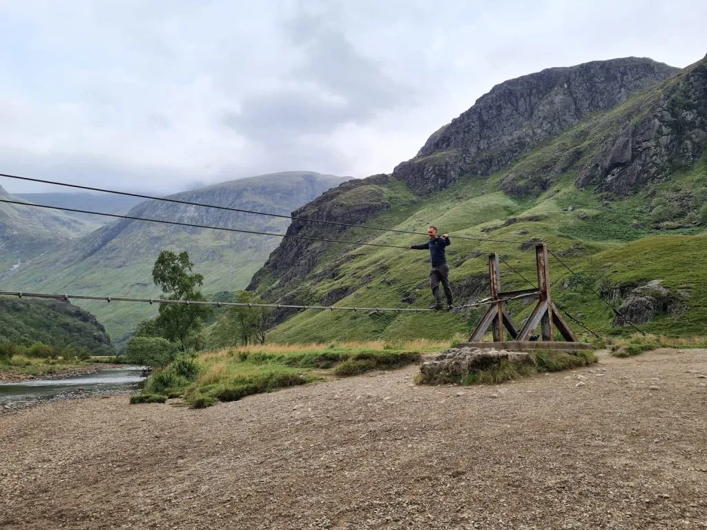 A man on the wire bridge crossing the River Nevis