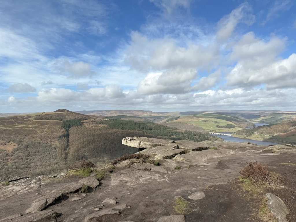 A protruding rock on Bamford Edge with a view of Ladybower Reservoir