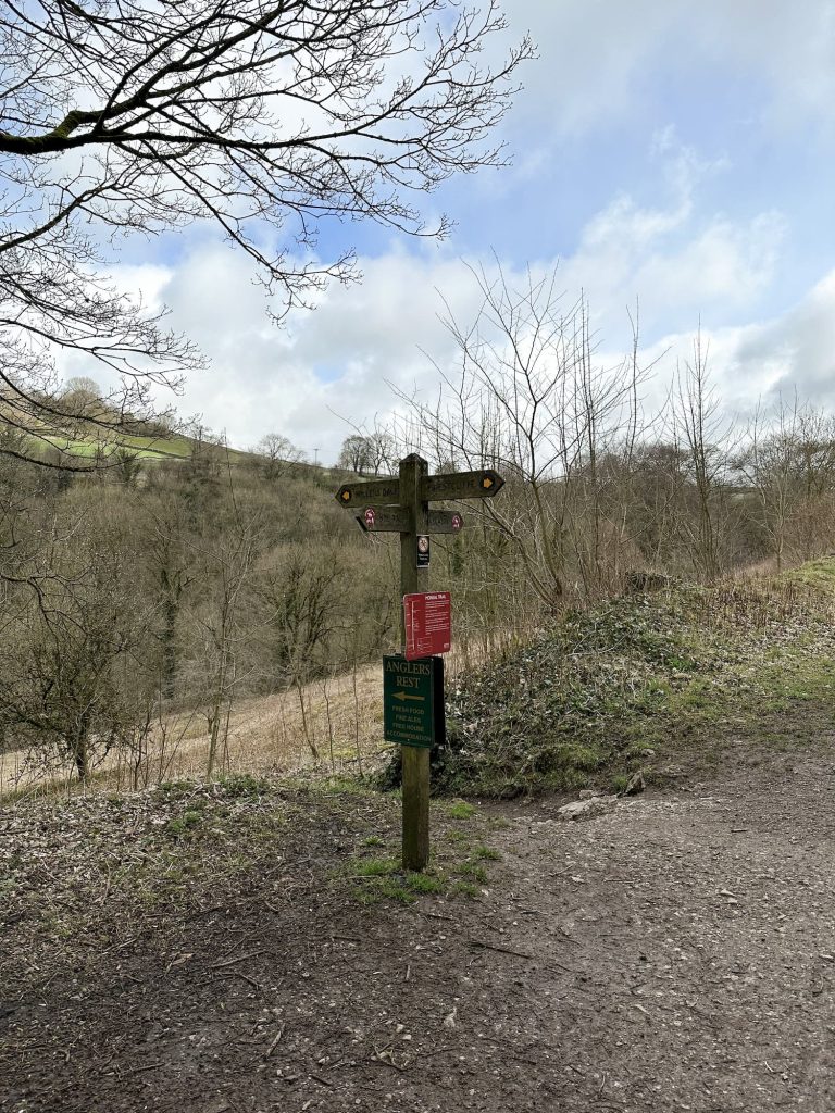 A wooden sign post on the Monsal Trail
