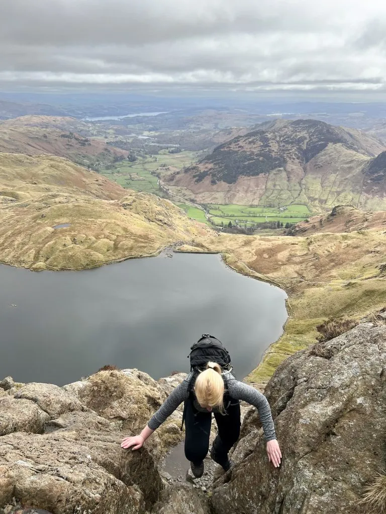 A blonde haired woman climbing a mountain in the Lake District