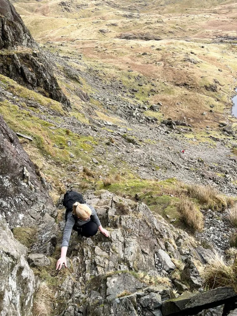 A view down to a woman scrambling up Jack's Rake