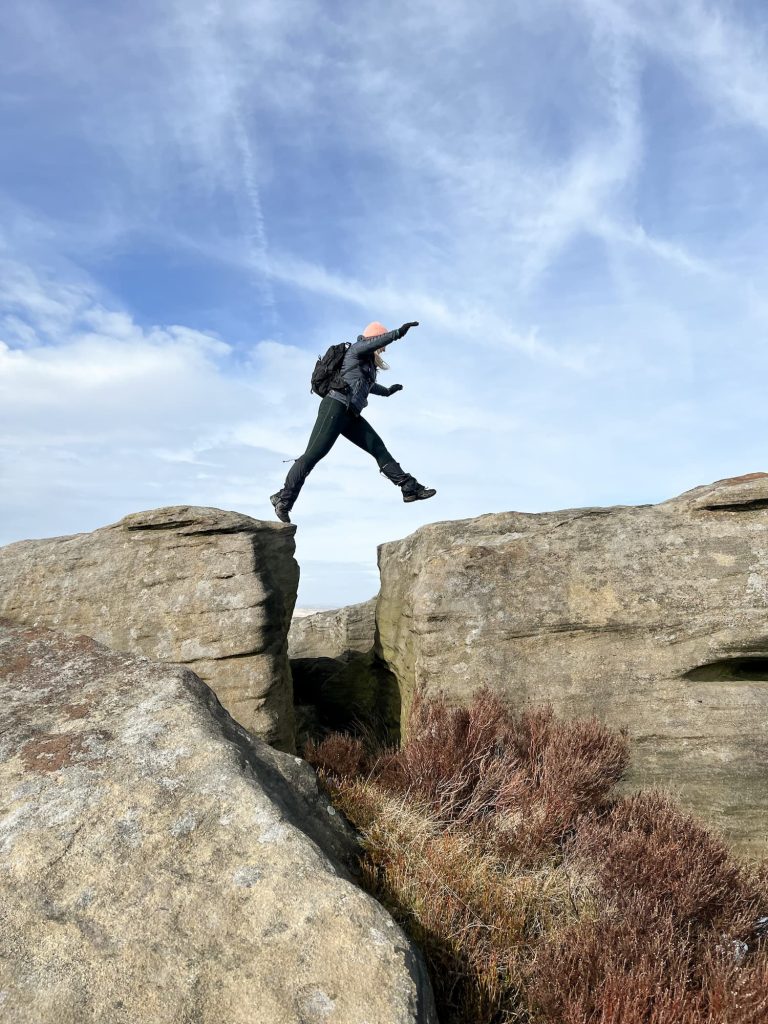 A woman jumping between two large rocks
