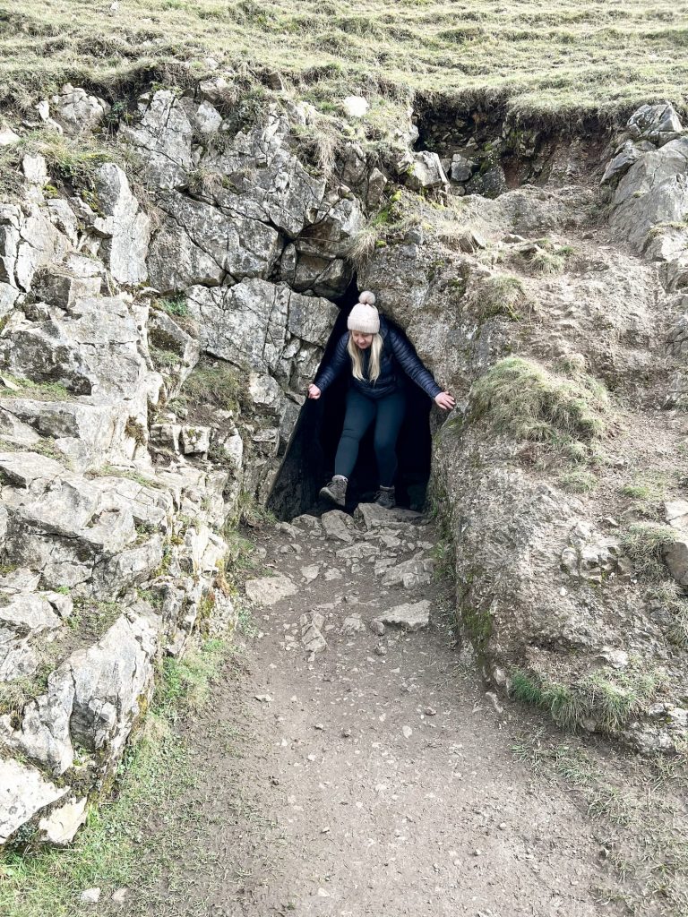 A woman coming out of a small cave