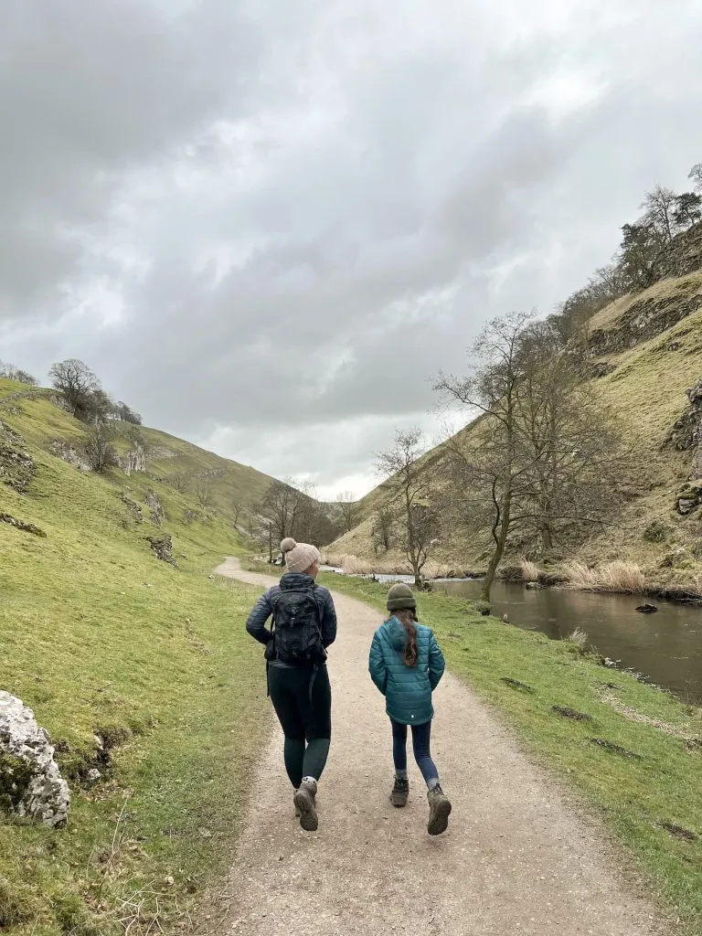 A woman and her daughter walking through the steep limestone valley of Wolfscote Dale