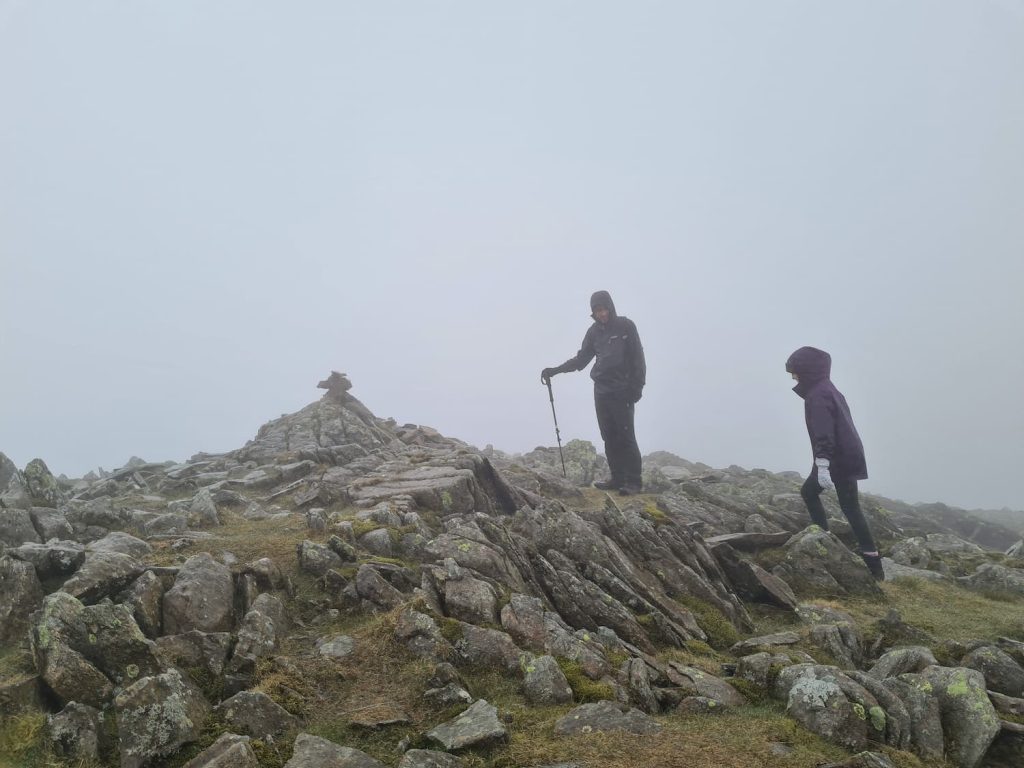 A father and daughter at the summit of one of the Lake District fells