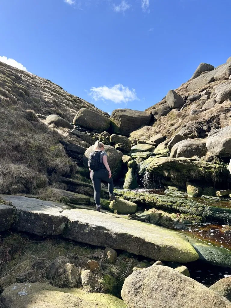 A woman looking up at some rocks
