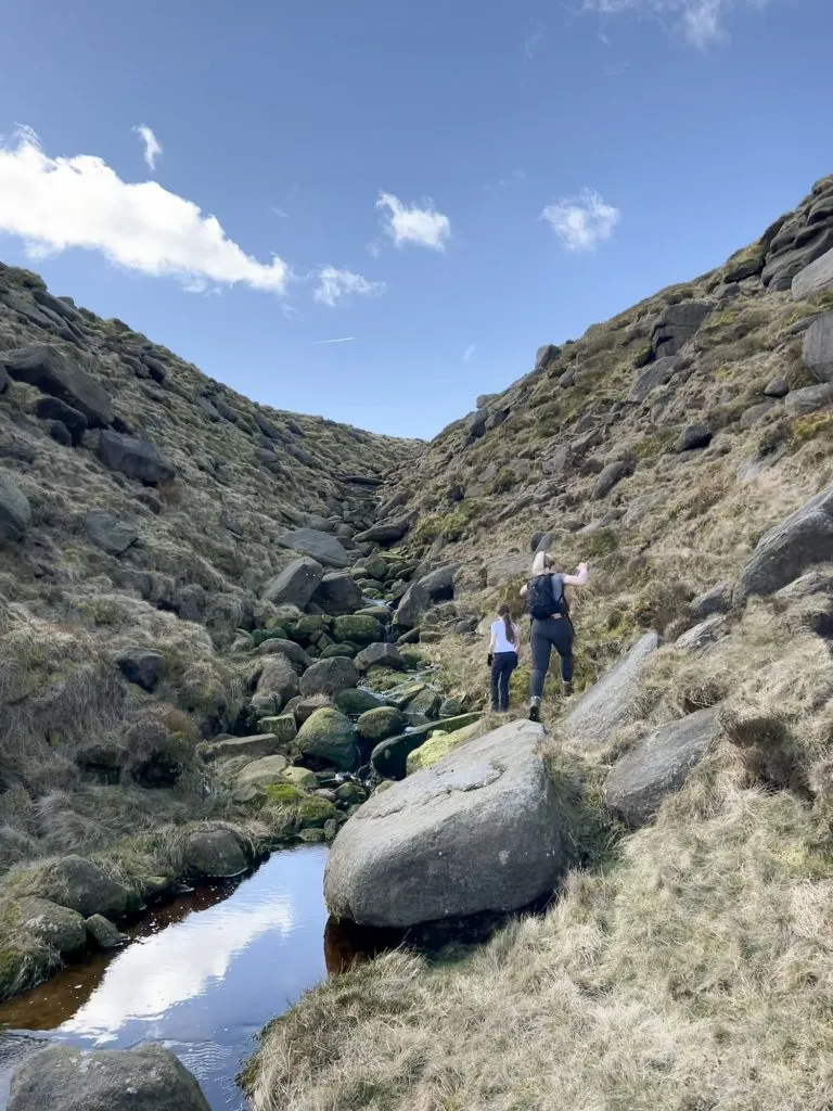 A woman and her daughter climbing some rocks