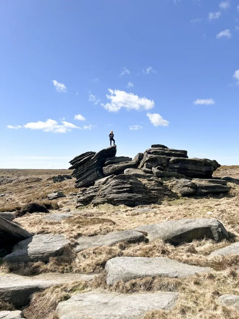 A small figure standing on a large rock formation