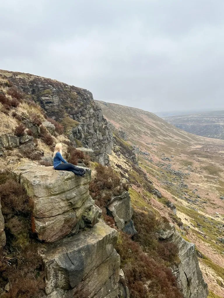 A woman sitting on some rocks at Laddow Rocks