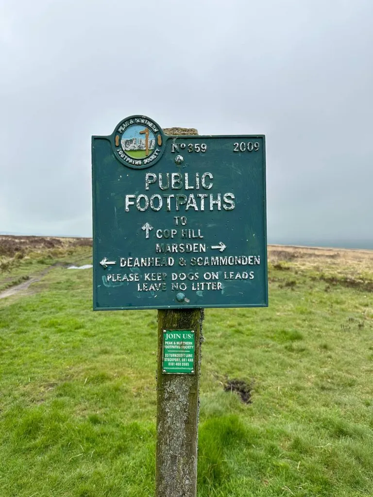 A green sign post with directions