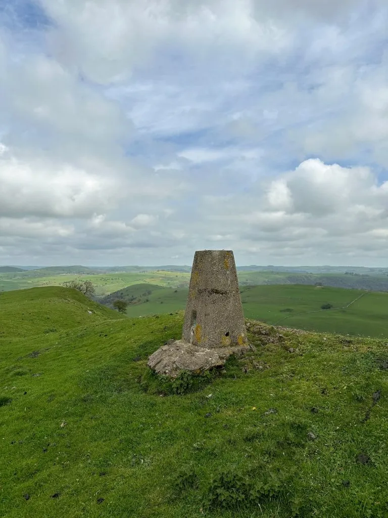 Soles Hill trig point, a grey concrete pillar, in a green field