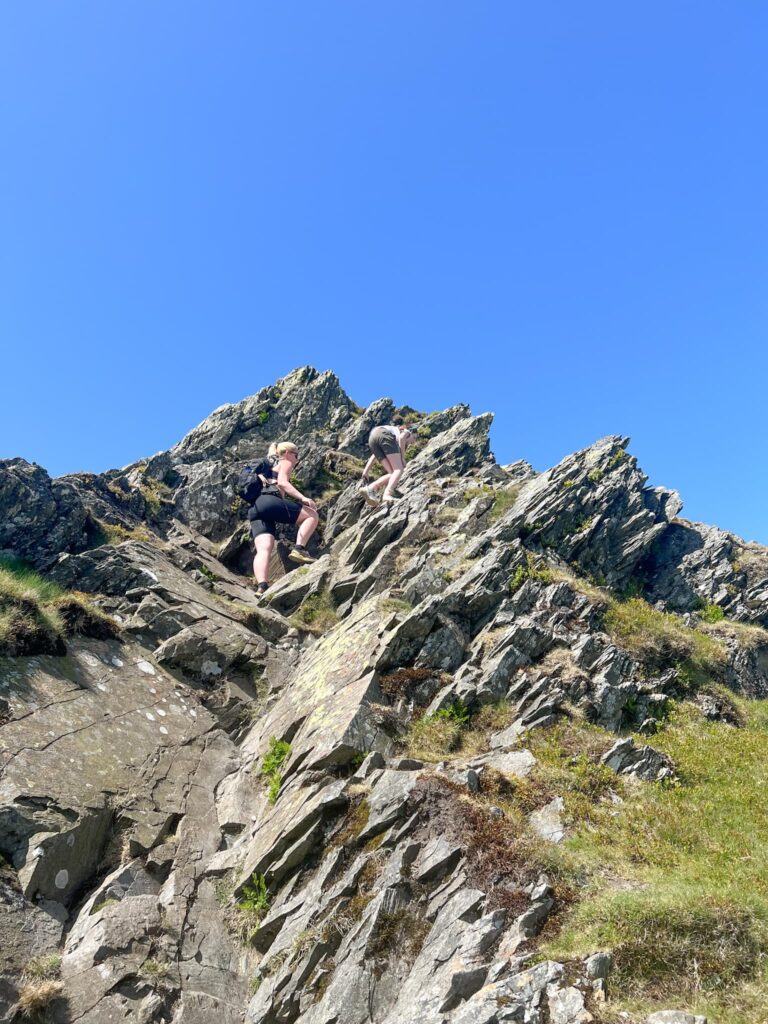 A woman climbing Sharp Edge