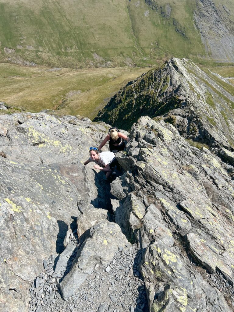 A woman and young girl climbing Sharp Edge