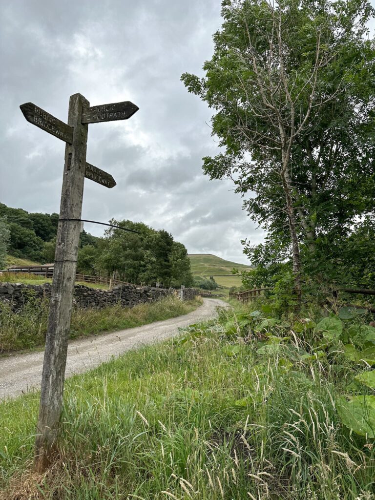 A wooden signpost with 3 markers