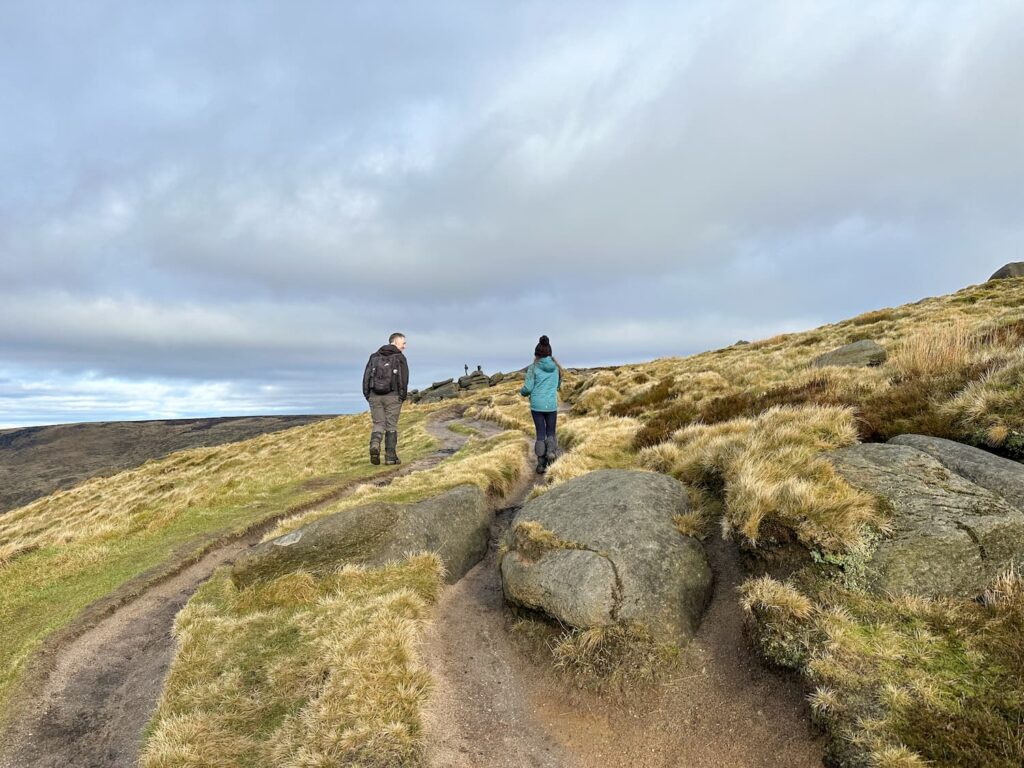 A man and his daughter walking on some moorland paths on Kinder Scout