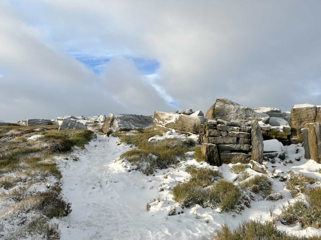 A snowy view of an old stone shelter on the moors