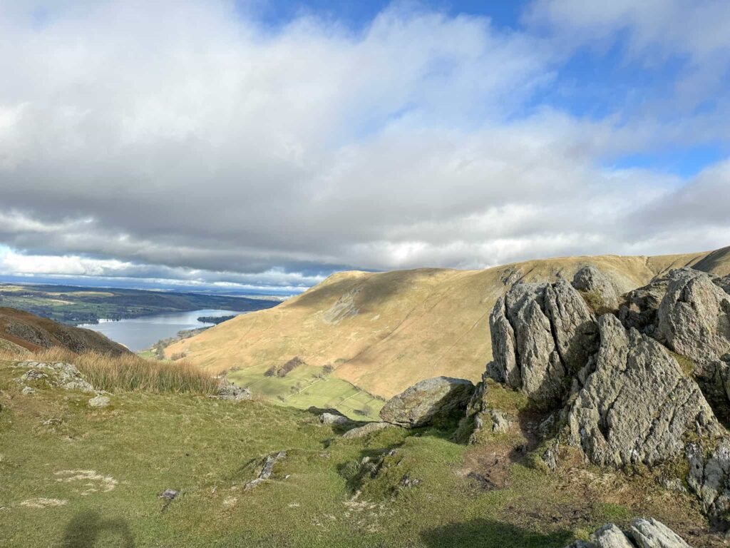 The view from one of the summits, with a rocky outcrop to the right of the image and a view to Ullswater on the left